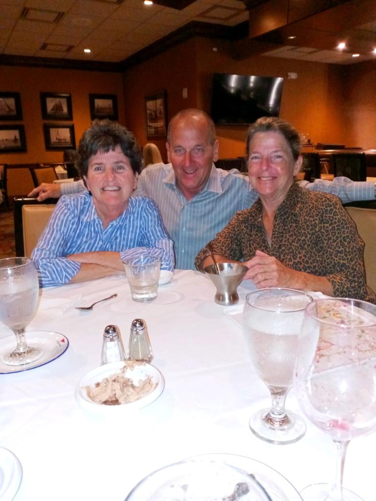 Christine Krauss Patel and family gathered around a dinner table, laughing.