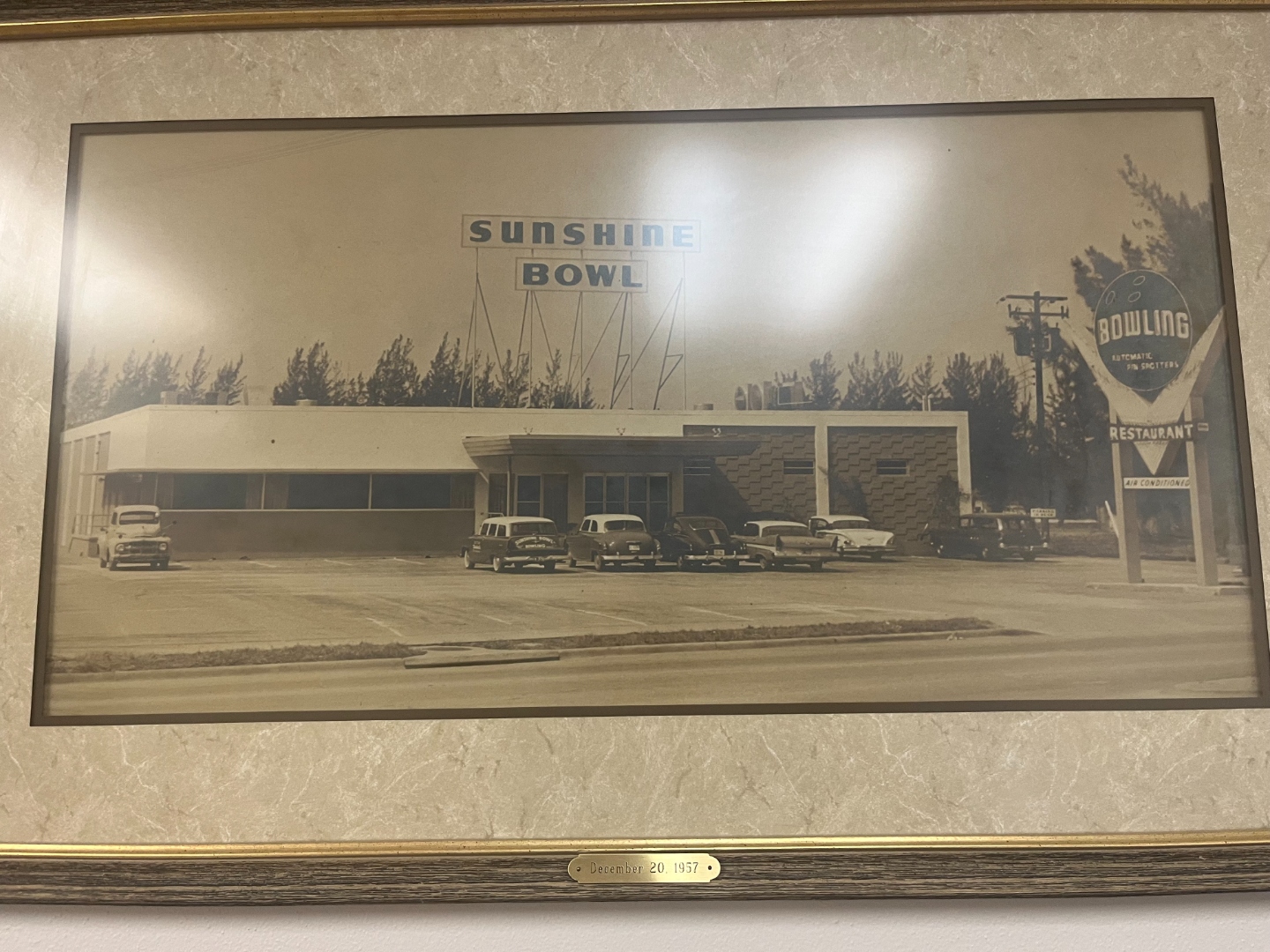 Framed archival photograph of the Sunshine Bowl bowling center in Pinellas Park, Florida, with 1950s cars parked outside and its signature signage.
